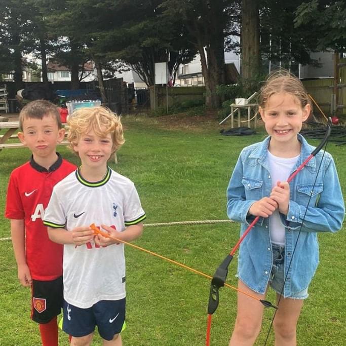 Young kids doing archery at a summer holiday camp in london