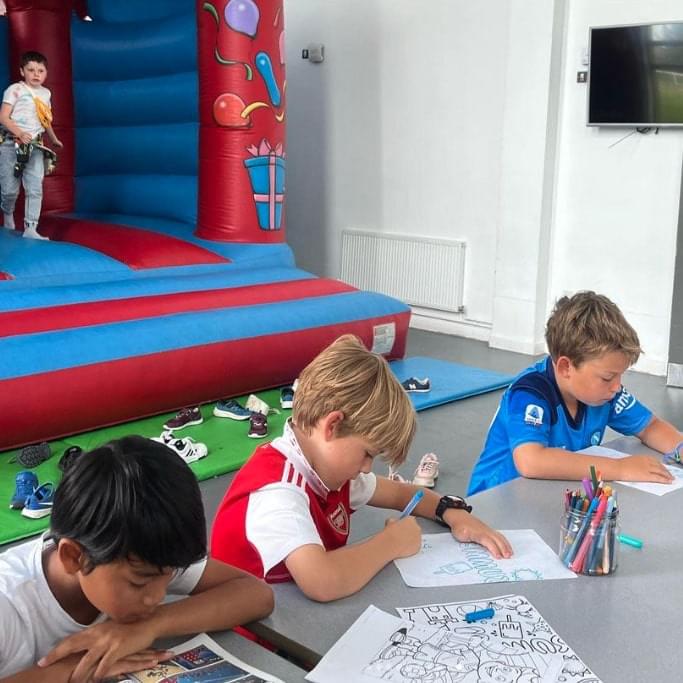 Young boys doing arts and crafts at a holiday camp in london