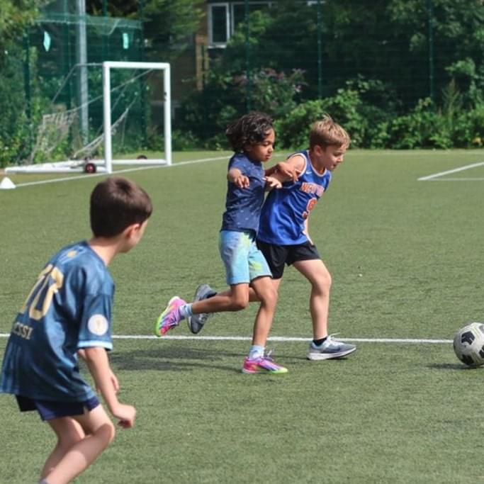 Kids playing football at a Summer holiday camp in london