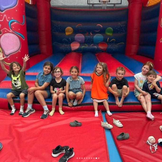 Bunch of young kids sitting on a bouncy castle